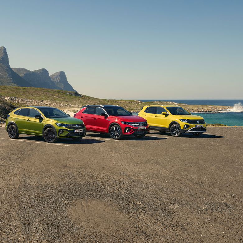 Taigo, T-Roc, T-Cross stehen geparkt auf einem Parkgelände, im Hintergrund sieht man das Meer.
