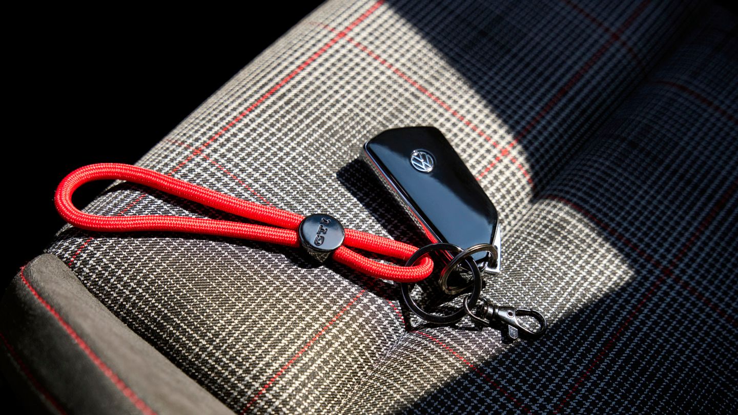 Golf GTI Schlüssel mit rotem Original GTI Schlüsselanhänger liegt auf Beifahrersitz