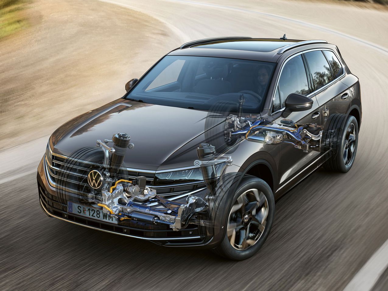 Grafik zeigt einen VW Touareg, der auf einer Straße fährt, mit transparenter Motorhaube, durch die man die Funktion der Allradlenkung erkennen kann.