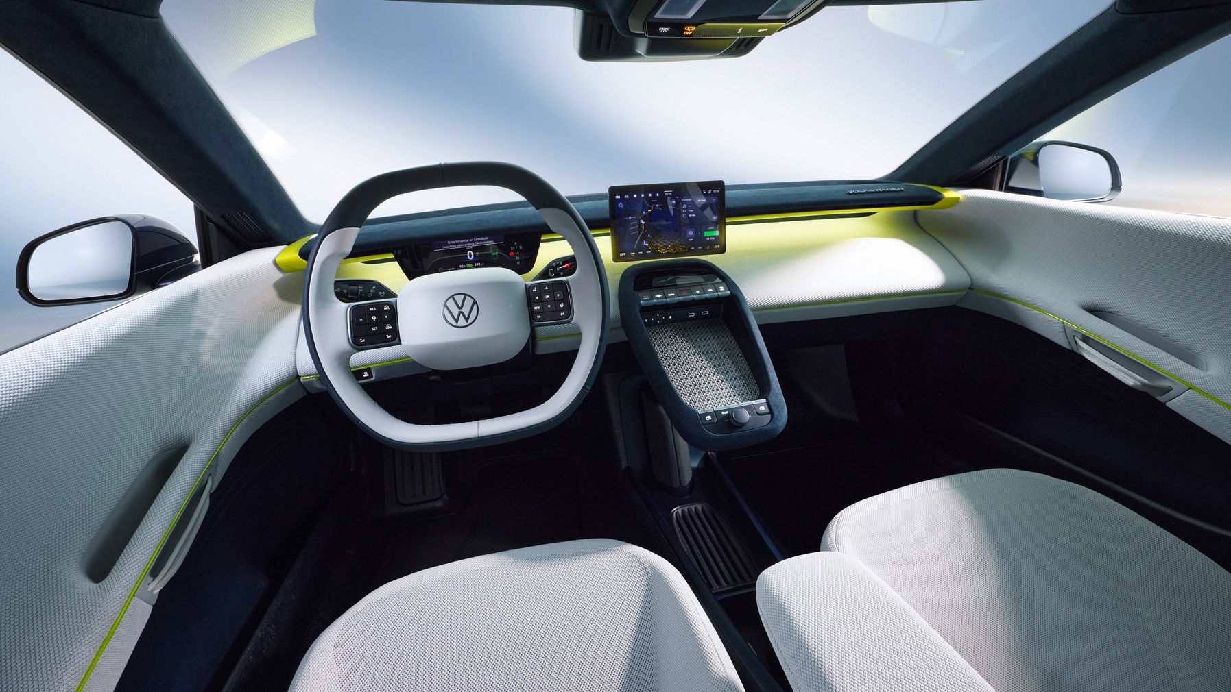Innenraum eines futuristischen VW-Autos mit großzügigem, hell gestaltetem Cockpit, großem zentralen Display und minimalistischem Armaturenbrett. Das Lenkrad ist eckig-rund mit VW-Logo, die Sitze sind in hellen Stofffarben gehalten. Gelbe Akzente an Armaturenbrett und Türen betonen das moderne, technische Design.
