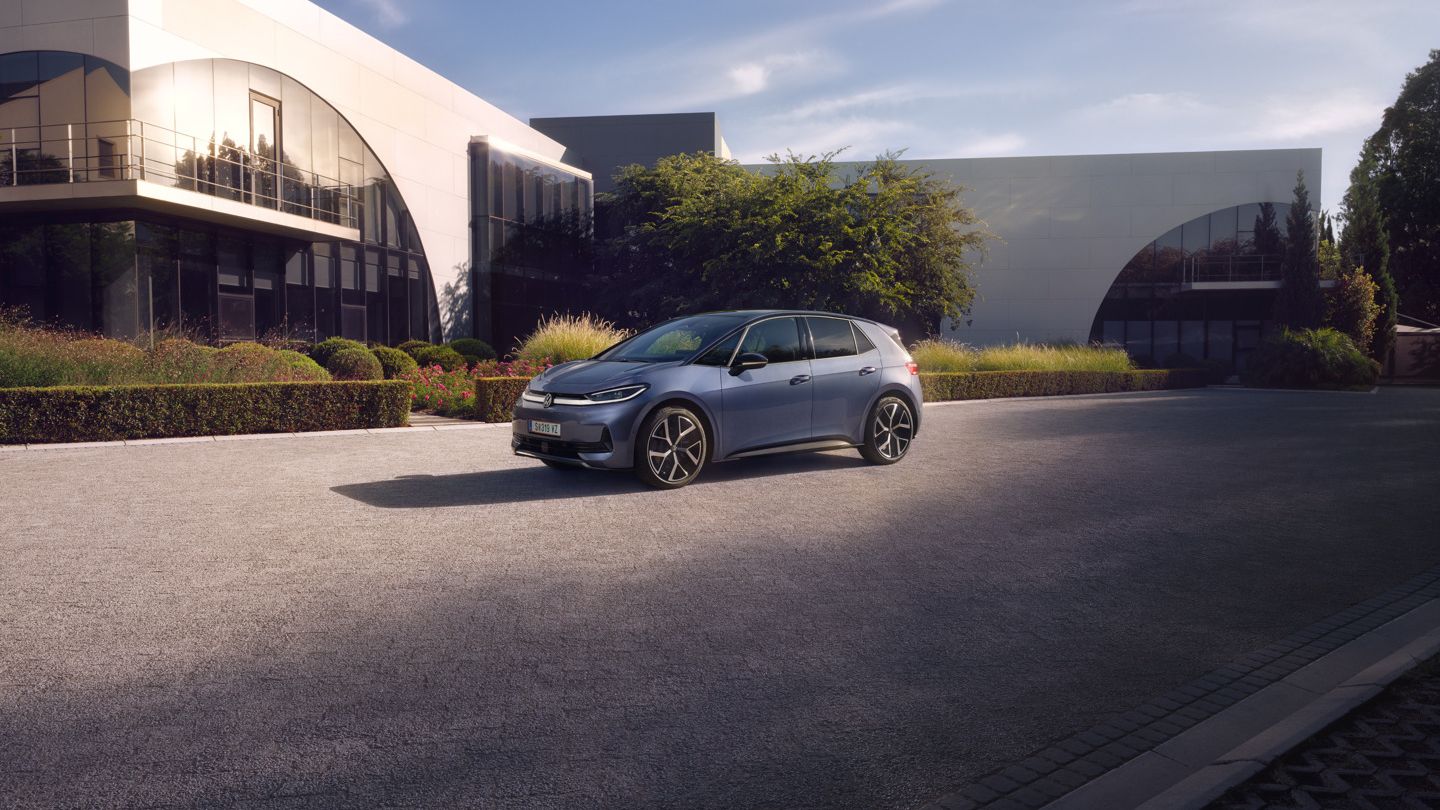 Ein blauer VW ID.3 Neo parkt vor einem modernen Gebäude