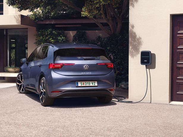 Ein blauer VW ID.3 Neo lädt an einer Wallbox vor einem Einfamilienhaus