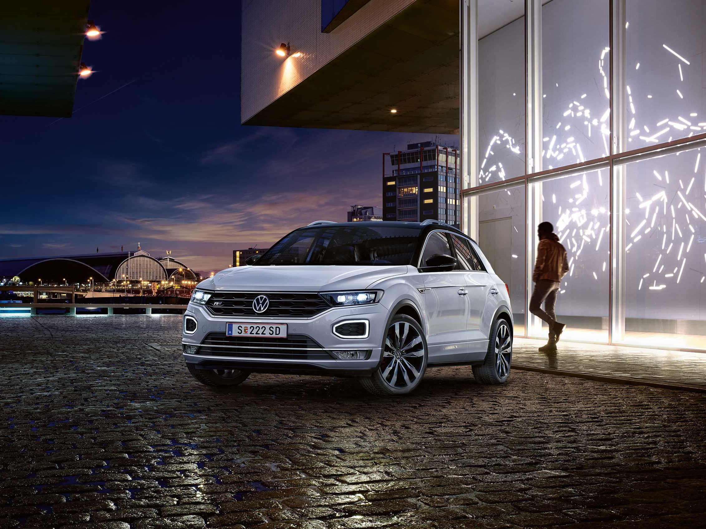 Person geht hinter VW T-Roc Vorgängermodell