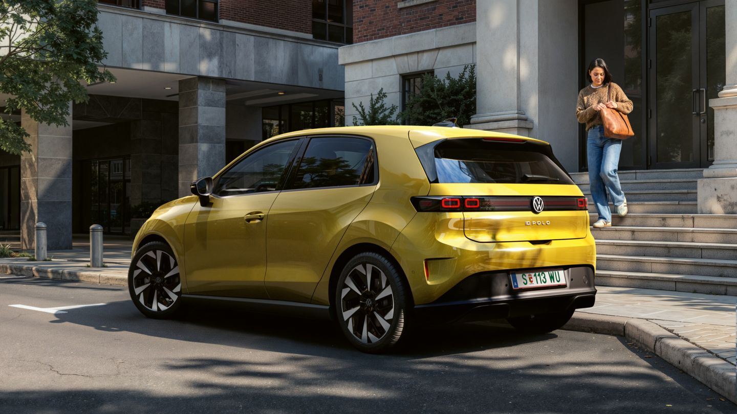 VW ID. Polo Trend in Pythongelb Metallic in 3/4‑Heckansicht, geparkt an einer urbanen Straße vor Wohngebäuden.