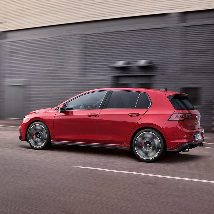 Seitenansicht eines roten Golf GTI der in der Stadt fährt