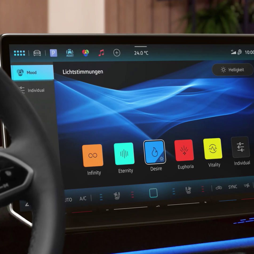 Ein Touchscreen im Auto zeigt verschiedene Optionen zur Lichtstimmung an, darunter "Infinity", "Eternity", und "Desire". Oben auf dem Bildschirm werden zusätzliche Informationen wie Temperatur und Uhrzeit angezeigt. Links ist ein Teil des Lenkrads sichtbar.