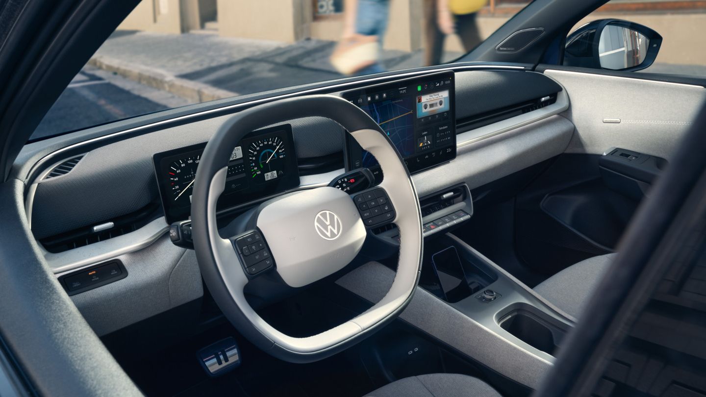 Blick durch die offene Fahrertür auf das Cockpit des VW ID. Polo Style, der am Straßenrand parkt.