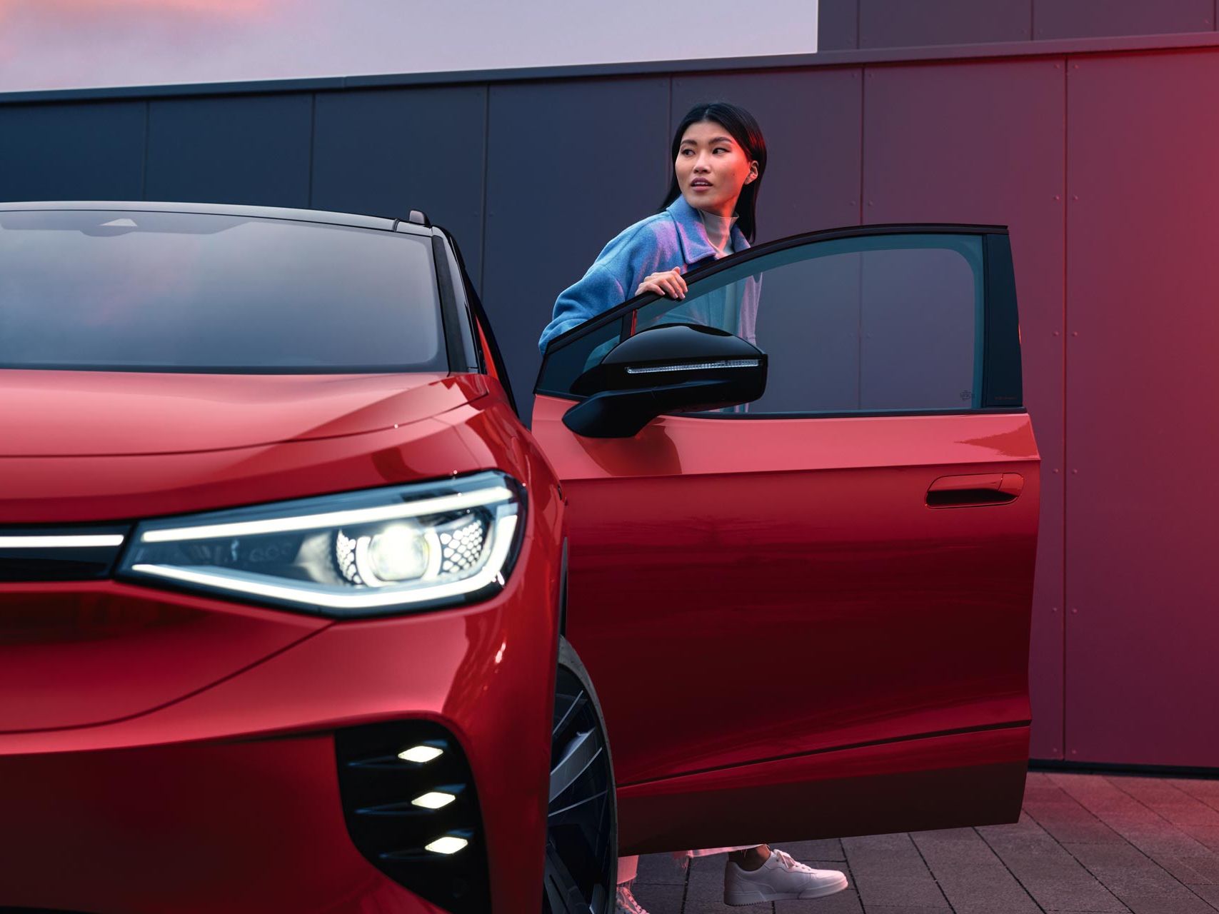 Frau steigt aus roten VW ID.4 GTX