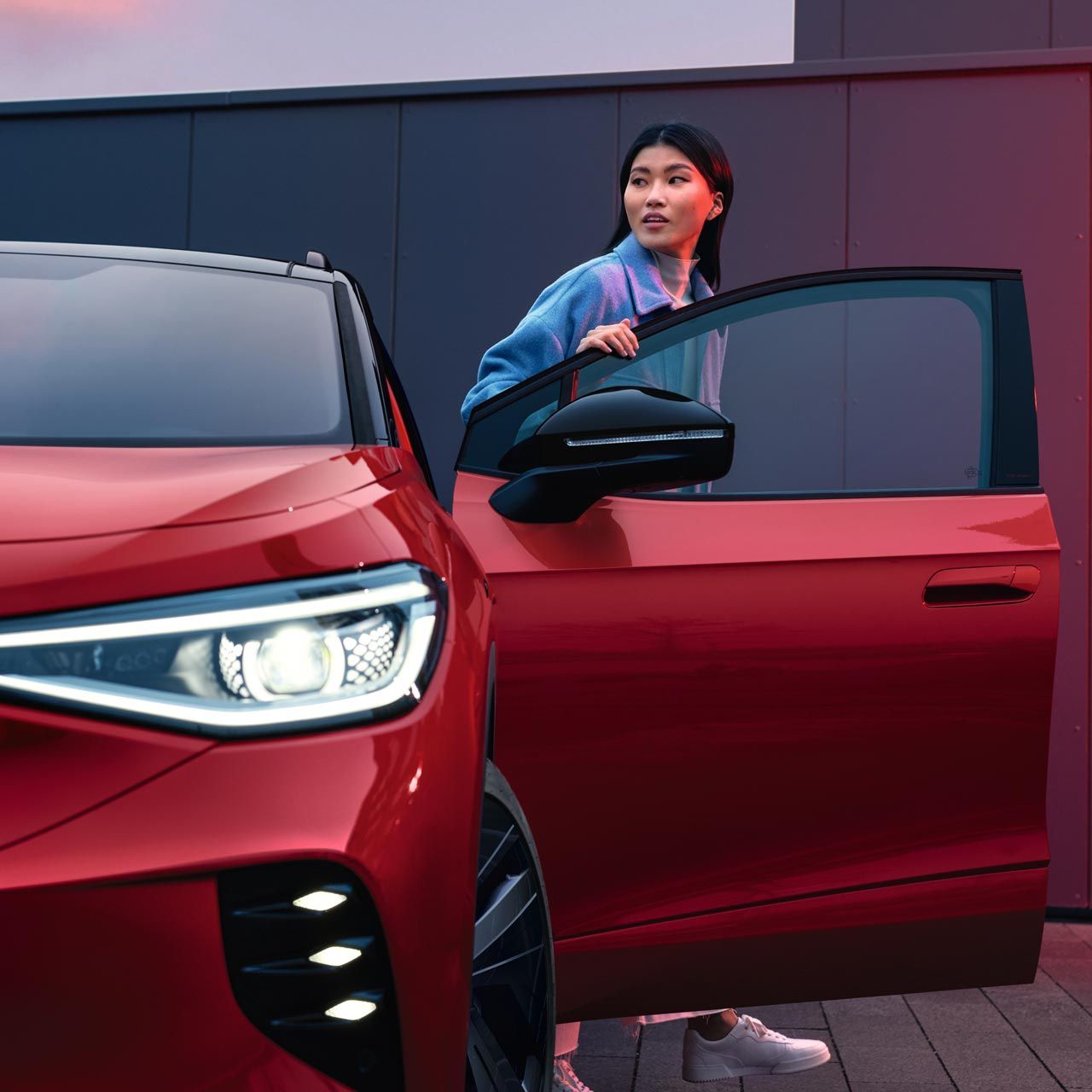 Frau steigt aus roten VW ID.4 GTX