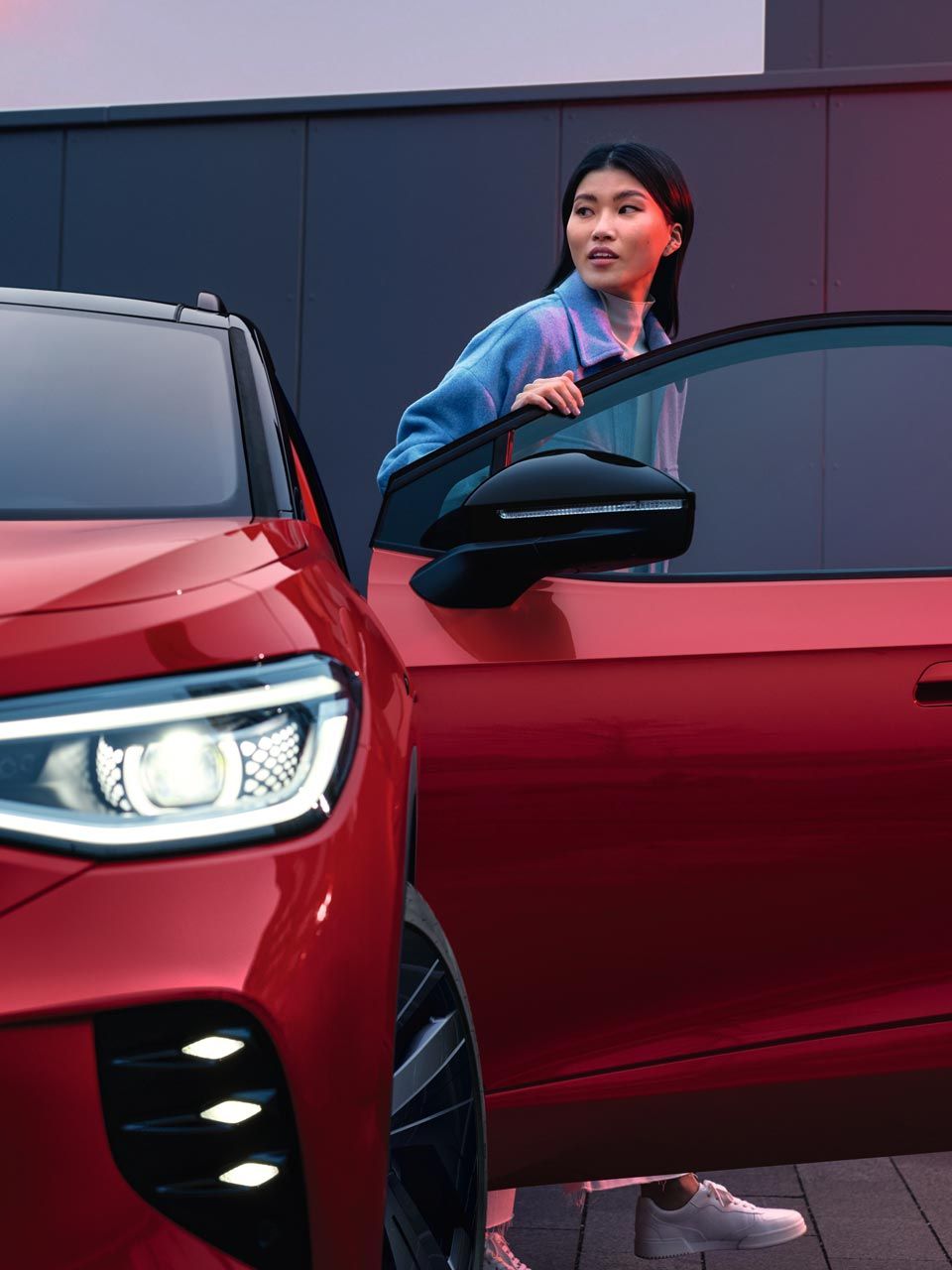 Frau steigt aus roten VW ID.4 GTX