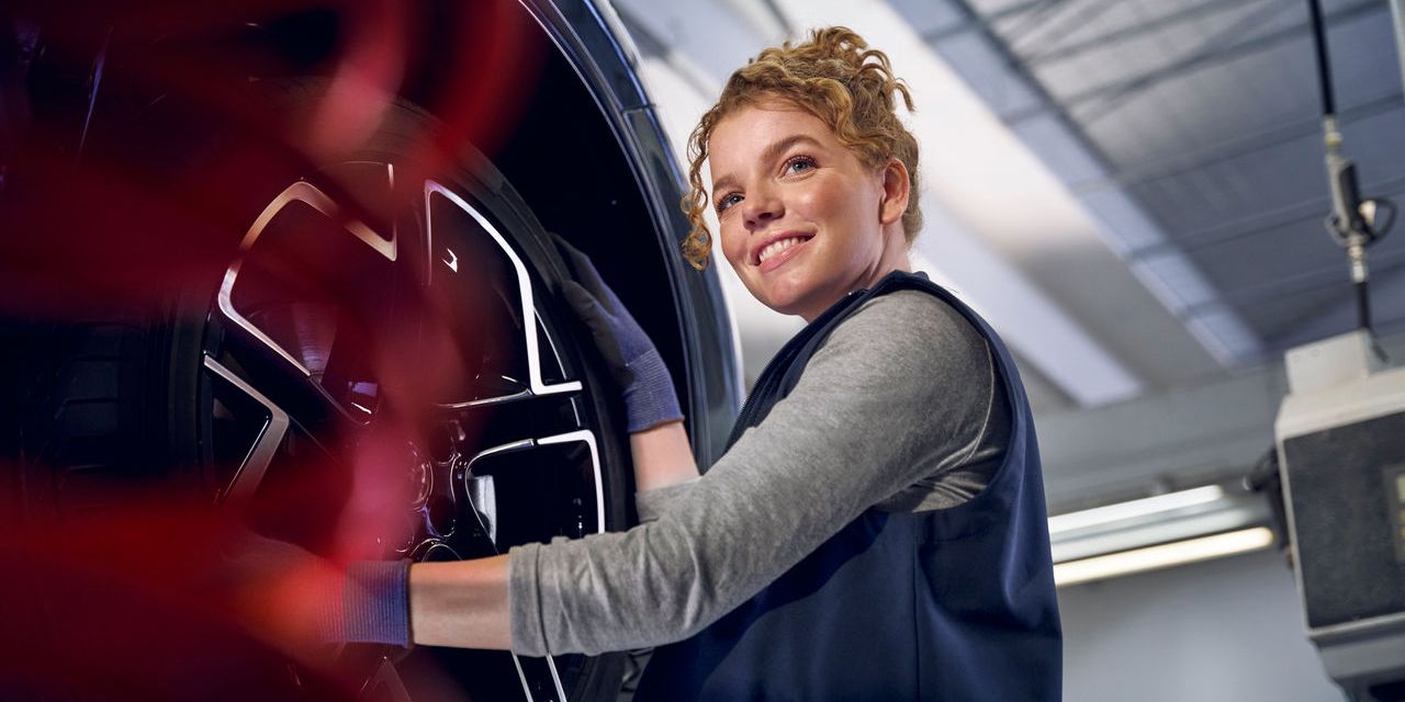 Eine Volkswagen Technikerin beim Reifenwechsel