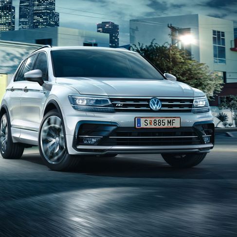 Ein Tiguan in der Ausstattungslinie R-Line fährt nachts um die Kurve