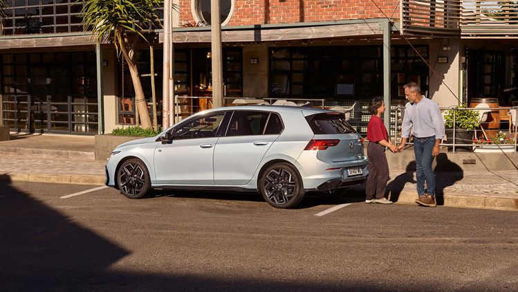 Der neue Golf GTE parkt an einem Straßenrand neben einem Café.