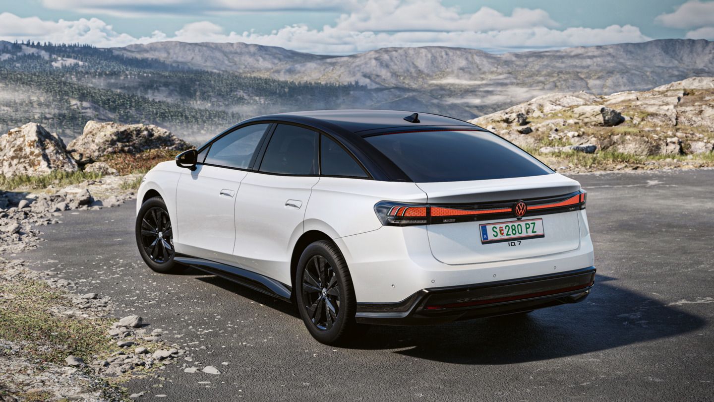 Weißer VW ID.7 in Heckansicht steht vor Felsen, im Hintergrund eine Berglandschaft.
