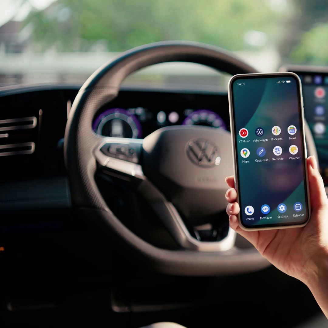 Frau sitzt auf dem Fahrersitz und spiegelt Smartphone per App Connect auf dem Fahrzeugdisplay