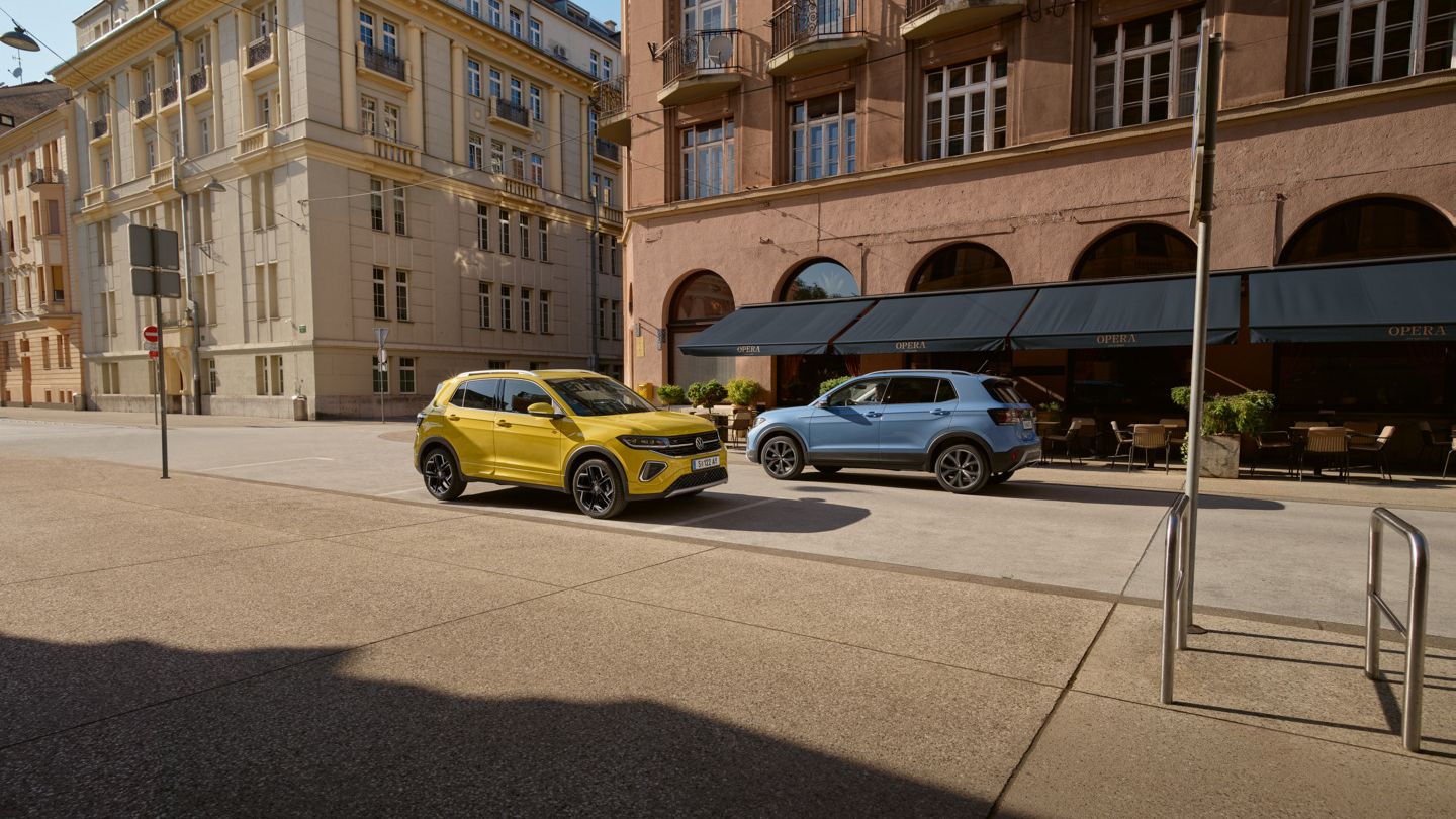 Ein gelber und ein blauer VW T-Cross in einer Stadt geparkt