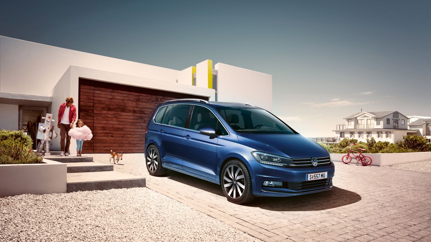 Ein blauer VW Touran geparkt vor Einfamilienhaus