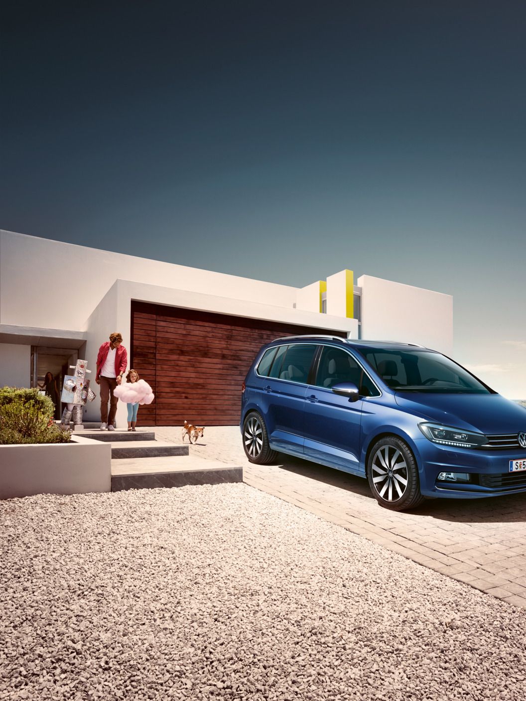 Ein blauer VW Touran geparkt vor Einfamilienhaus