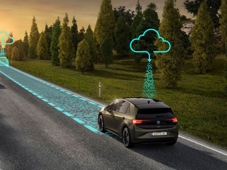 Zwei Autos fahren auf einer Landstraße bei Sonnenaufgang. Eines der Autos zeigt Vernetzungs- und Navigationsdaten, die in die Wolke hochgeladen werden. Es symbolisiert den Connected Travel Assist