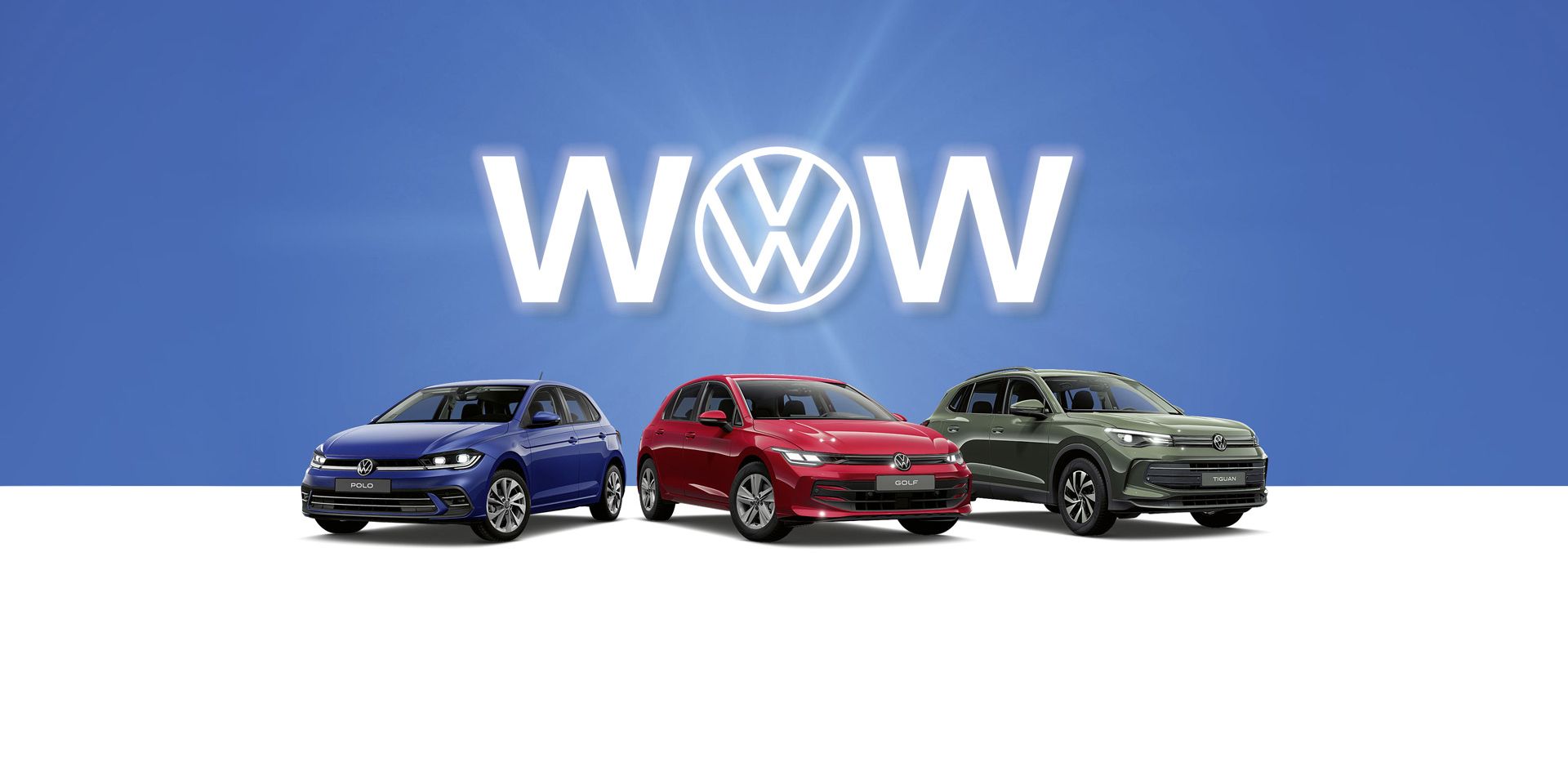 Drei Volkswagen-Autos, ein Polo, Golf und ein Tiguan stehen nebeneinander vor einem blauen Hintergrund. Hinter den Autos ist das Volkswagen-Logo und das Wort "WOW" zu sehen. Die Autos sind von links nach rechts blau, rot und grün.