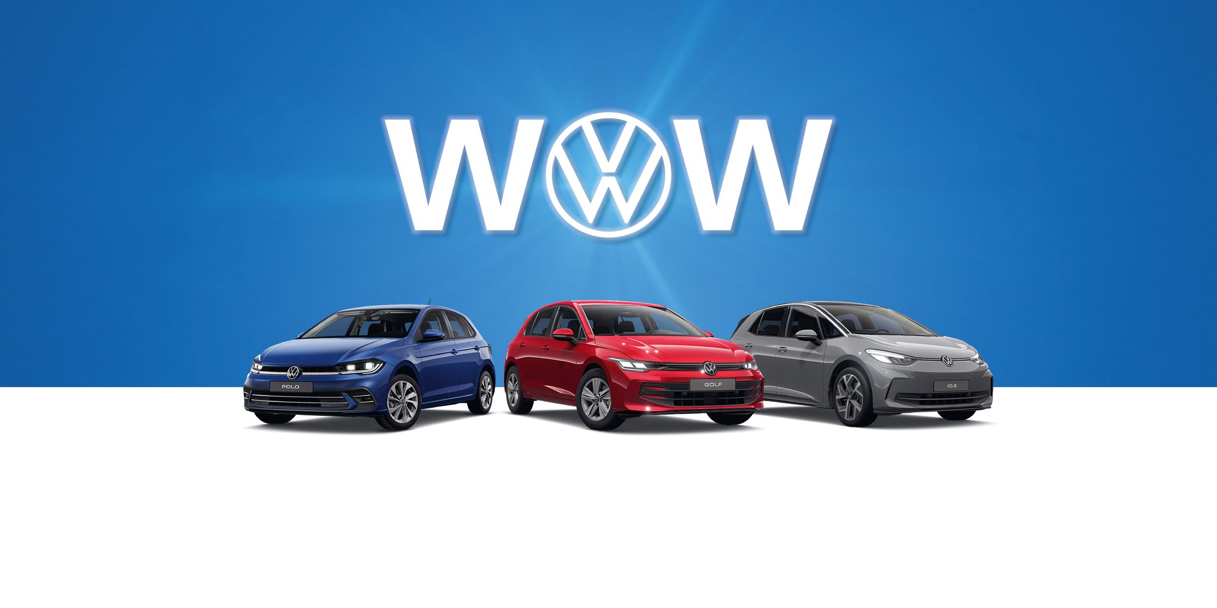 Drei Volkswagen-Autos, ein Polo, Golf und ID.3 stehen nebeneinander vor einem blauen Hintergrund. Hinter den Autos ist das Volkswagen-Logo und das Wort "WOW" zu sehen. Die Autos sind von links nach rechts blau, rot und grau.