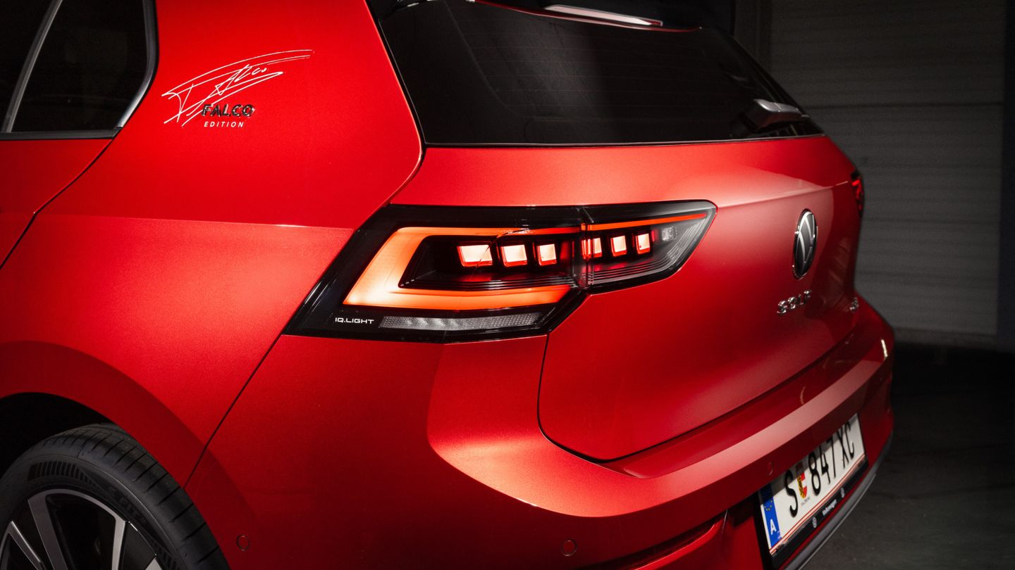 Detailaufnahme des Hecks eines roten VW Golf Falco Edition. Auf der C-Säule ist die Unterschrift von Falco zu sehen.