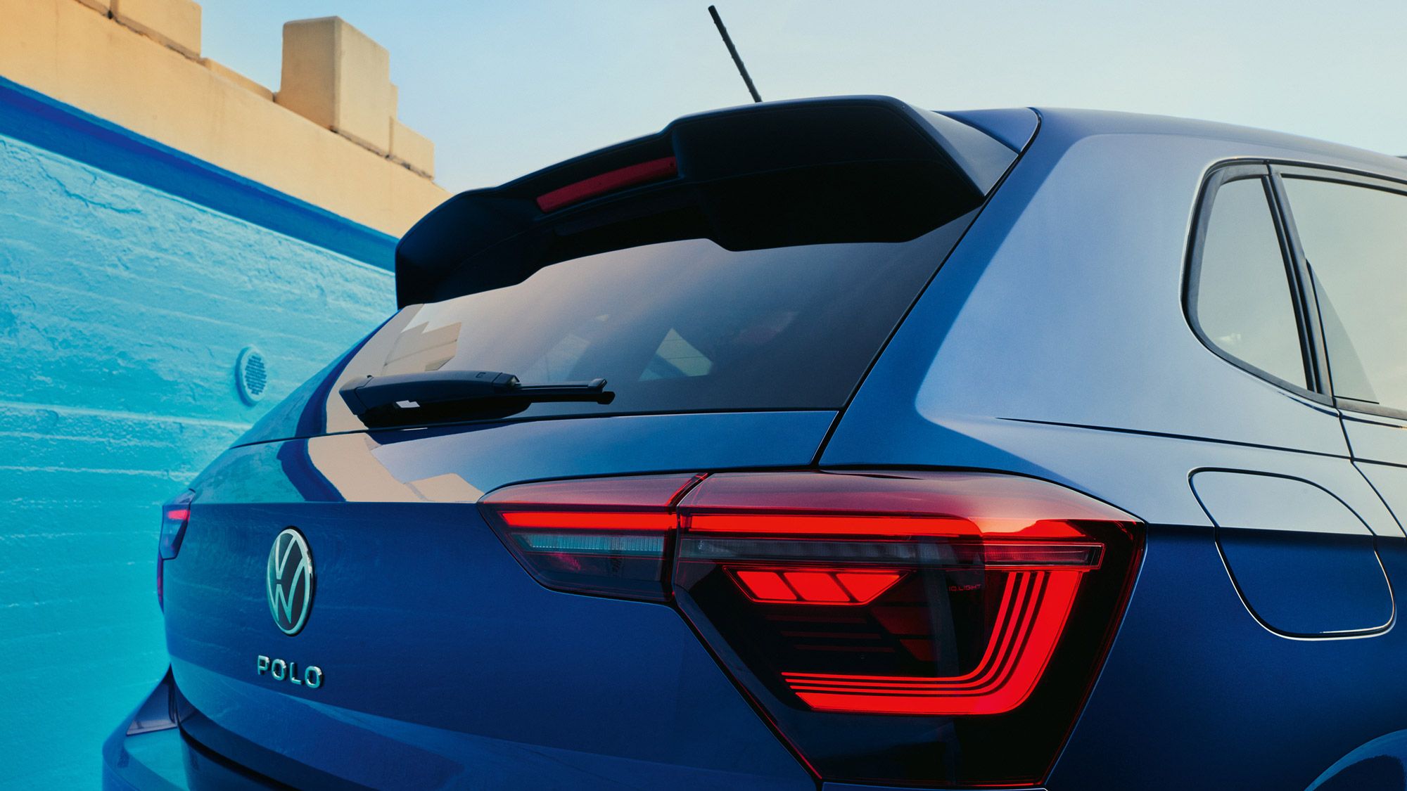 Heckansicht eines blauen VW Polo mit Fokus auf die Heck-Lichtsignatur.