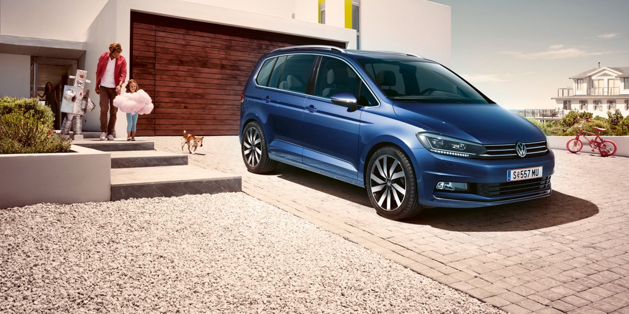 Ein blauer VW Touran geparkt vor Einfamilienhaus