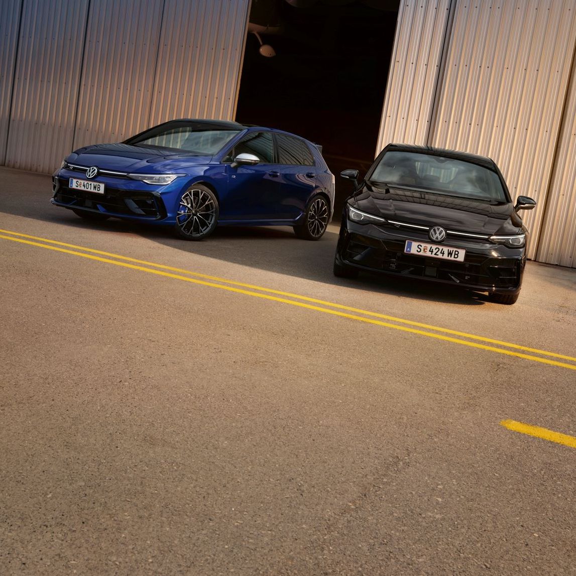 Zwei Golf R stehen vor geöffneter Lagerhalle.