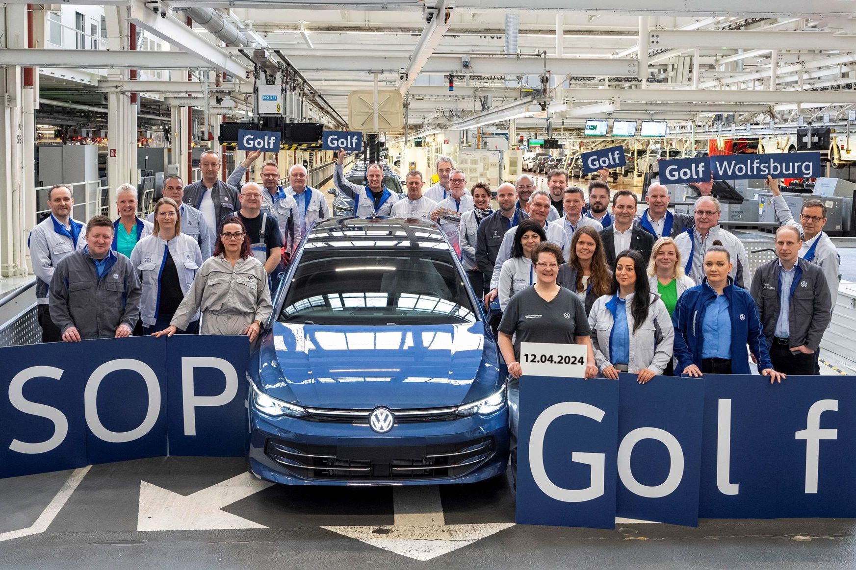 Der erste neue VW Golf 8 geht vom Band. Die Mitarbeiter jubeln. 