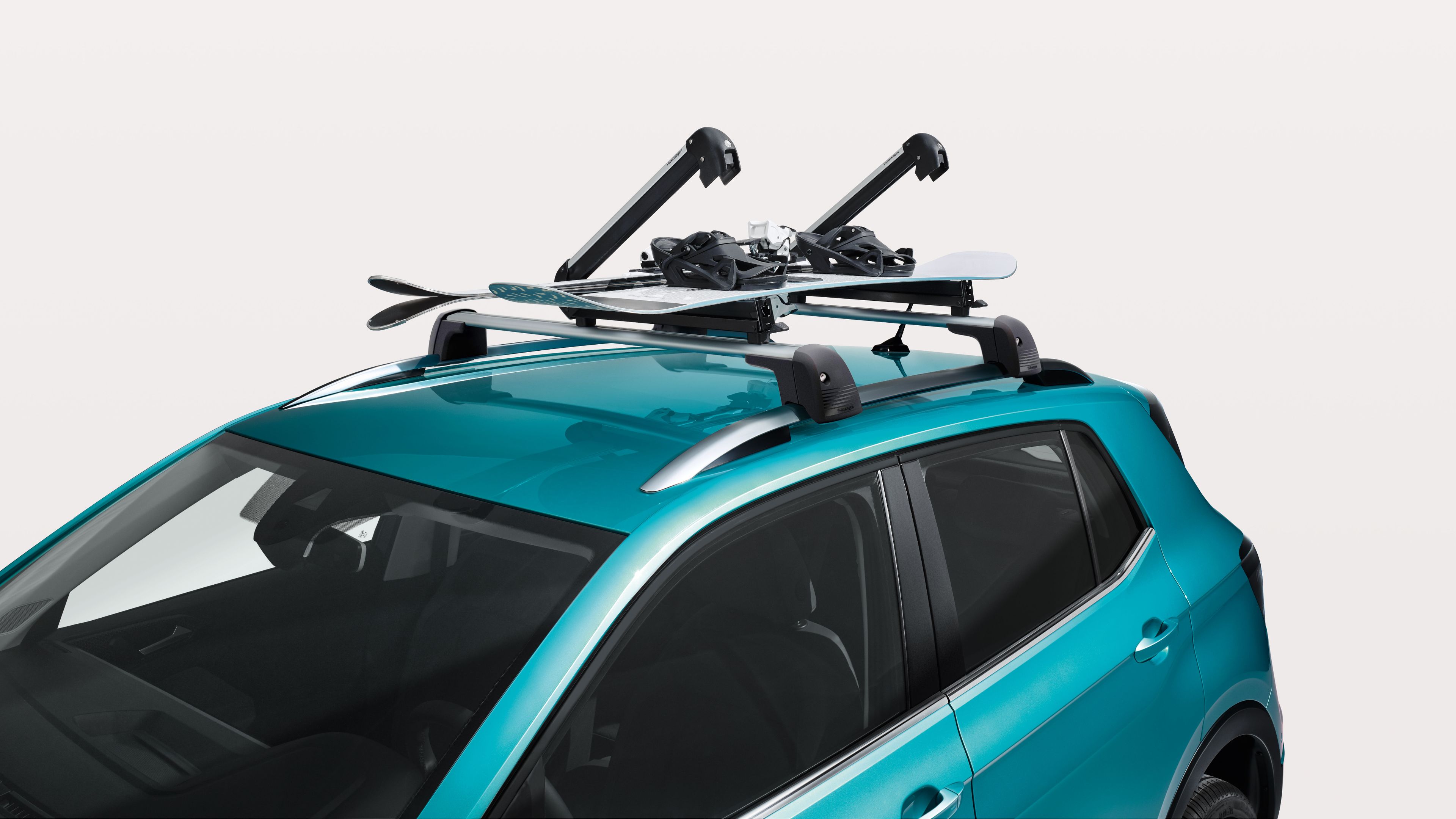 Volkswagen Original Snowboardhalter geöffnet am Dach eines türkisen Volkswagen.