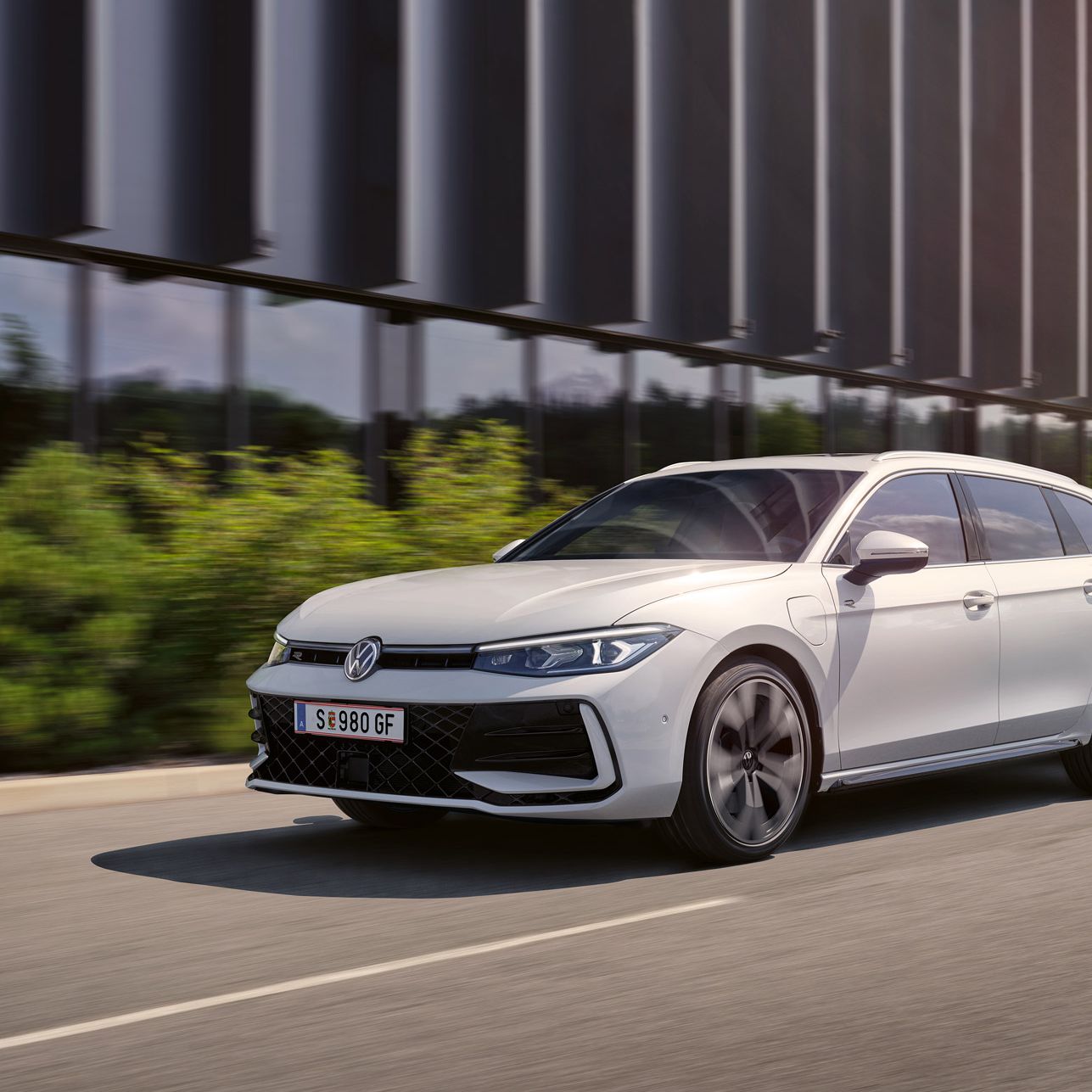 Ein weißer VW Passat R-Line fährt in einer Stadt