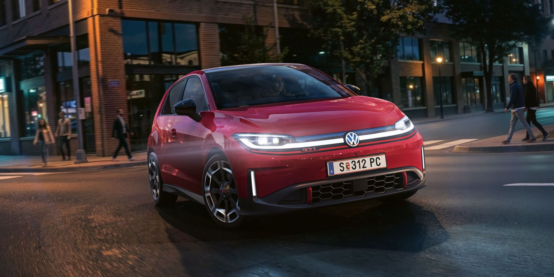 Ein roter VW ID. Polo GTI biegt bei abendlicher Stimmung in eine Straße ein.
