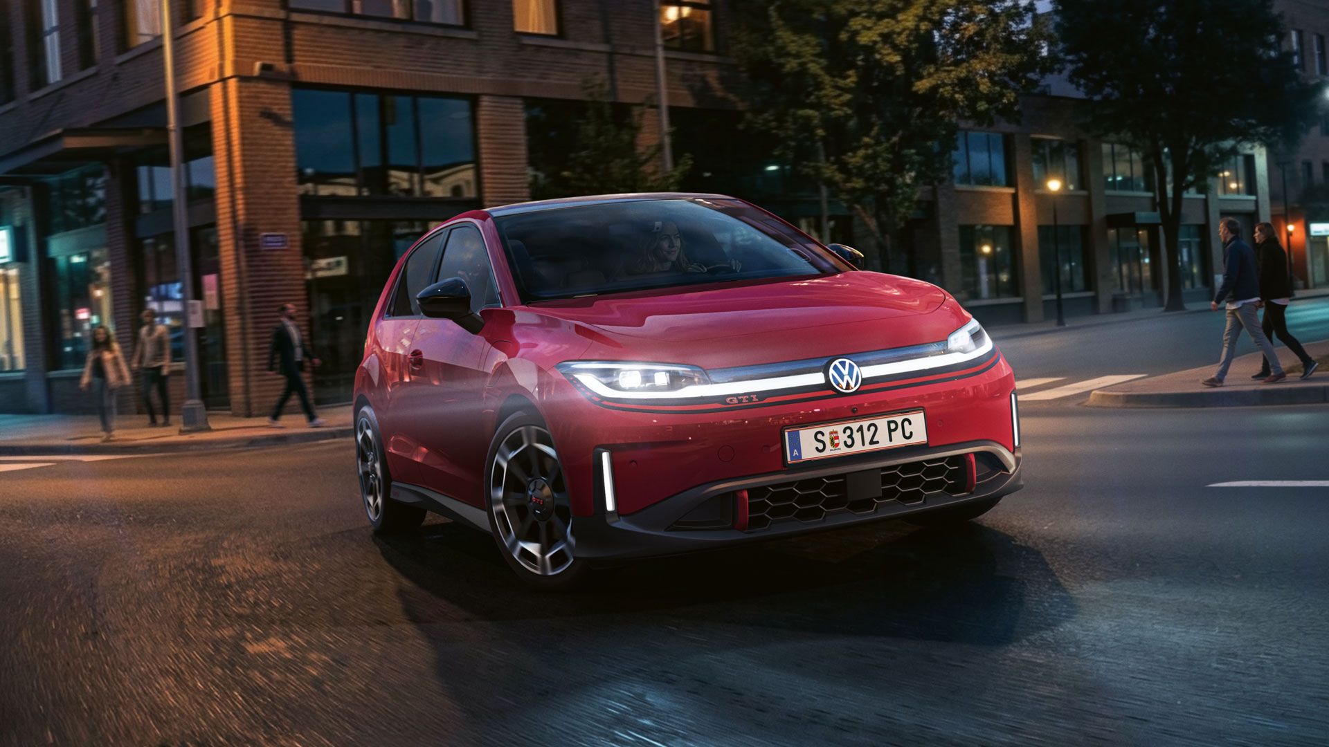 Ein roter VW ID. Polo GTI biegt bei abendlicher Stimmung in eine Straße ein.