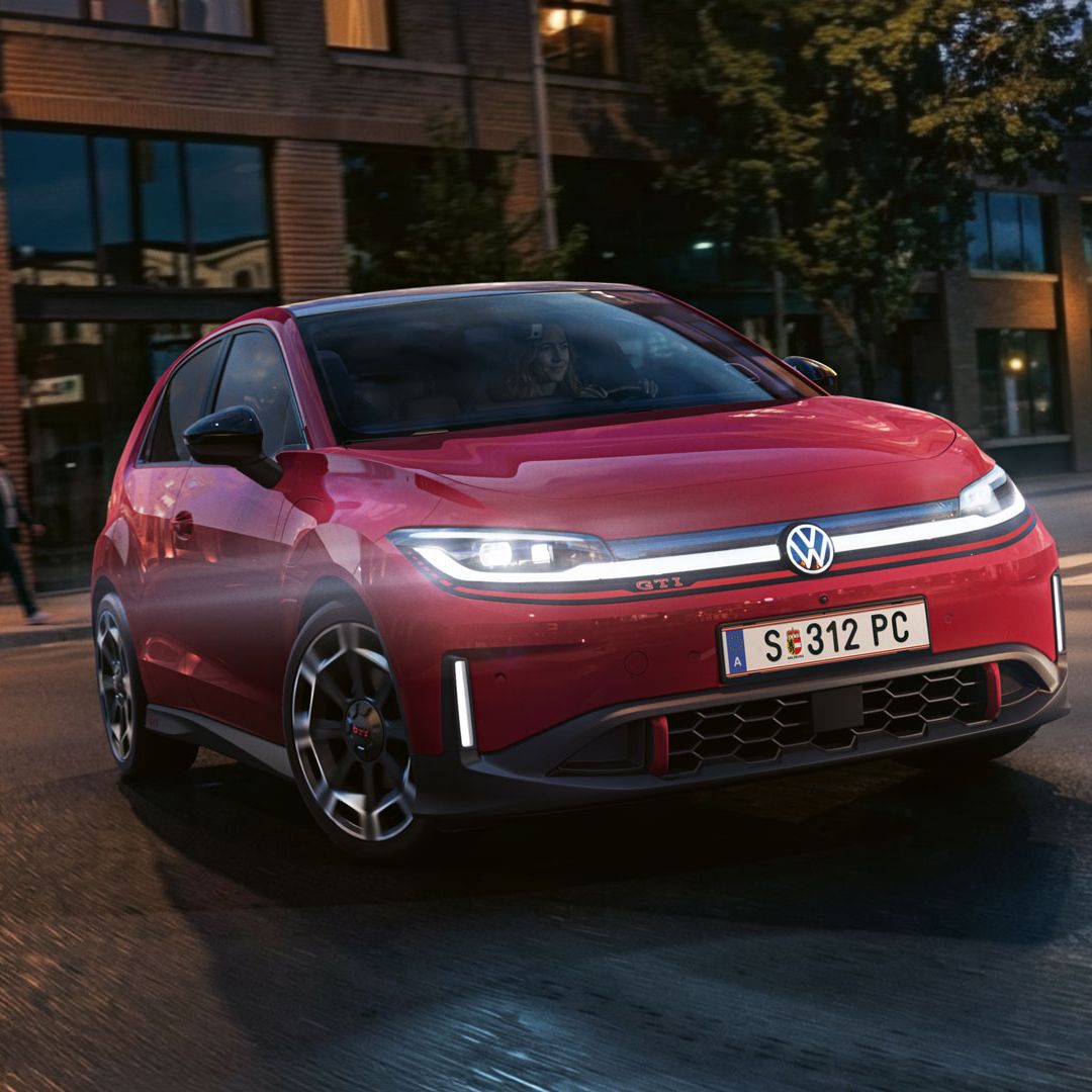 Ein roter VW ID. Polo GTI biegt bei abendlicher Stimmung in eine Straße ein.