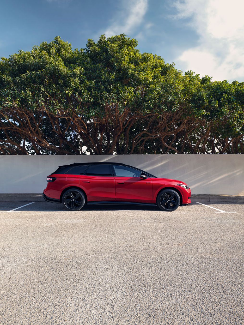 Der VW ID.7 Tourer GTX parkt vor einem Baum (Seitenansicht)