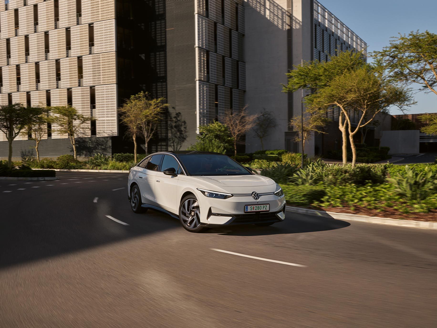 Ein weißer VW ID.7 fährt in einer Kurve in einer Stadt