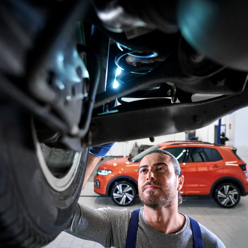 Ein VW Techniker überprüft einen Volkswagen Stoßdämpfer