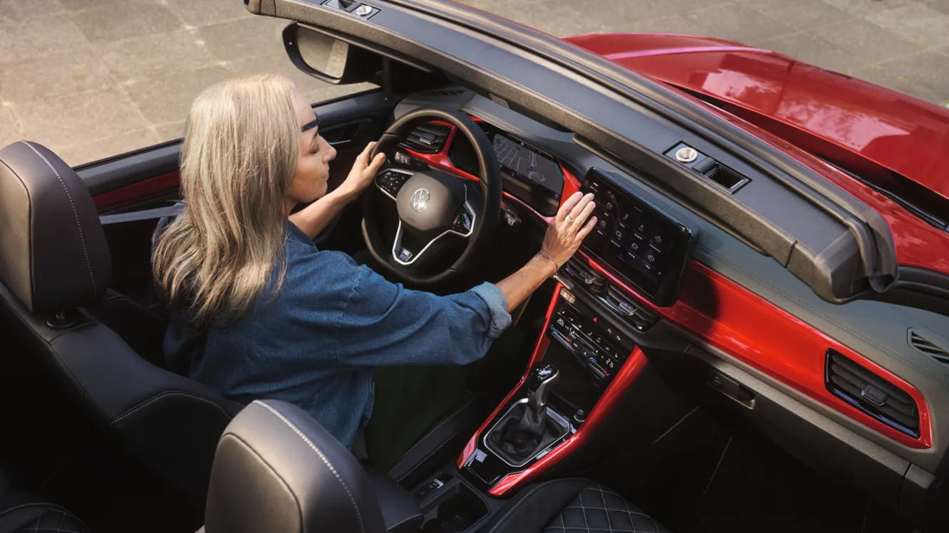 Frau bedient Navigationssystem im VW T-Roc Cabrio.