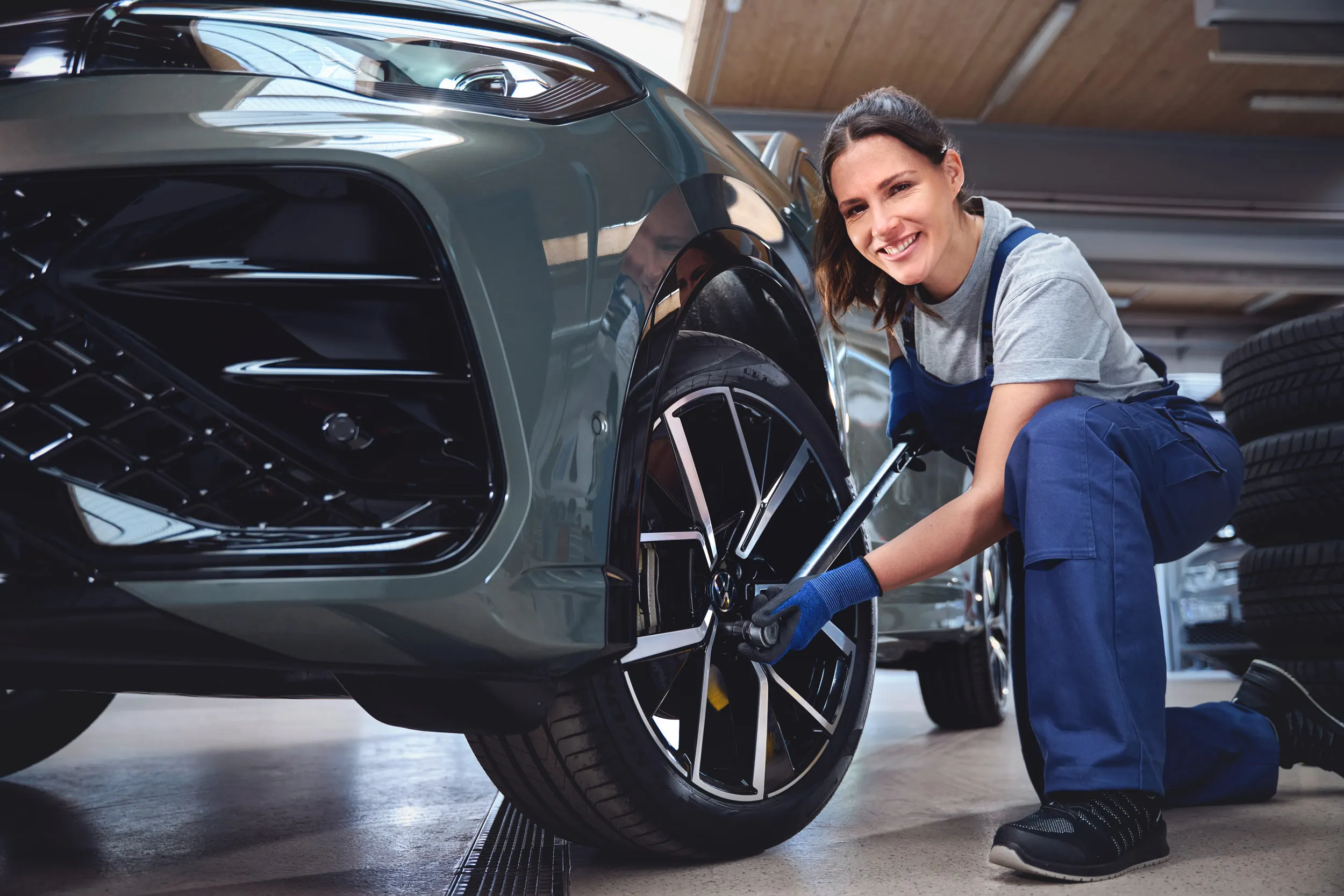 Eine Volkswagen Technikerin beim Reifenwechsel von einem Volkswagen Tiguan.