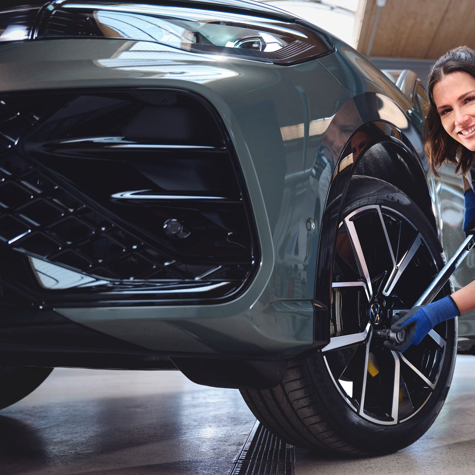 Eine Volkswagen Technikerin beim Reifenwechsel von einem Volkswagen Tiguan.