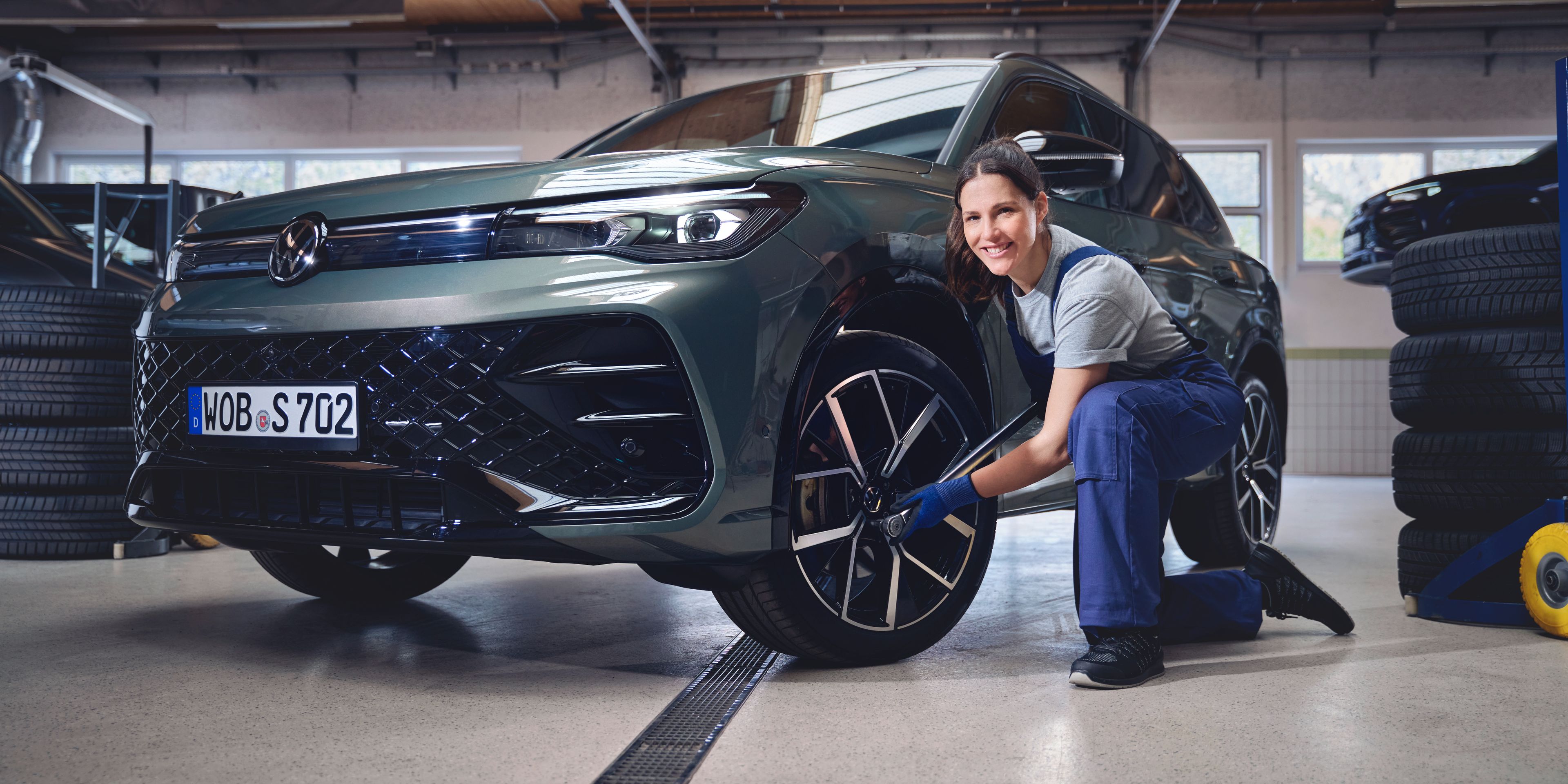 Eine Volkswagen Technikerin beim Reifenwechsel von einem Volkswagen Tiguan.