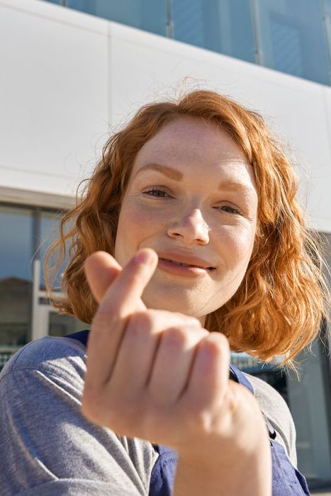 Volkswagen Service Mitarbeiterin vor dem Eingang zu einem Volkswagen Service Partner