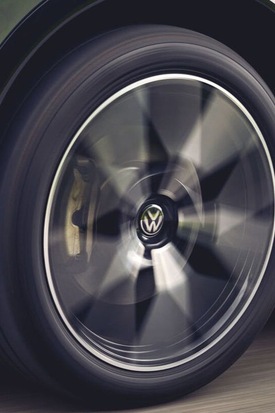 Eine Detailaufnahme des linken Vorderrads eines grünen VW Tiguan.