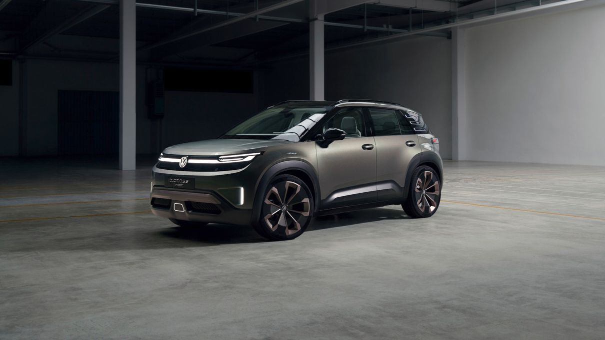 Auf dem Bild sieht man die Seitenansicht sowie die Front des VW ID. Cross Concept. Er steht in einer Halle.