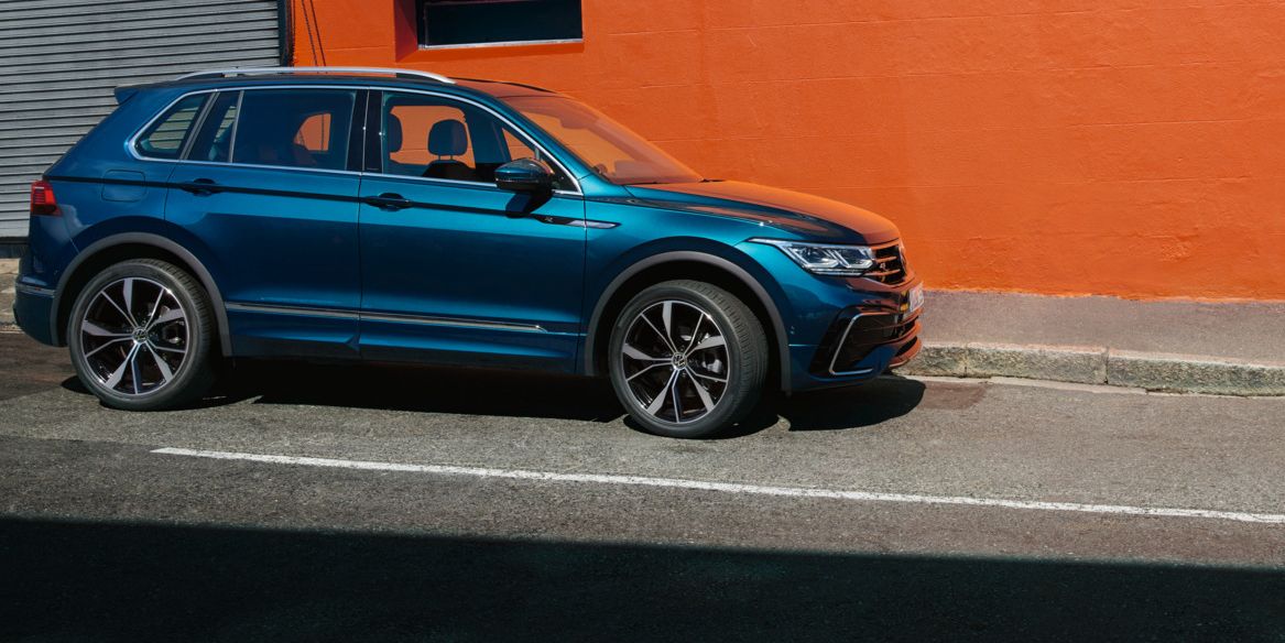 VW Tiguan R-Line in Grau von hinten. Mann steht davor.