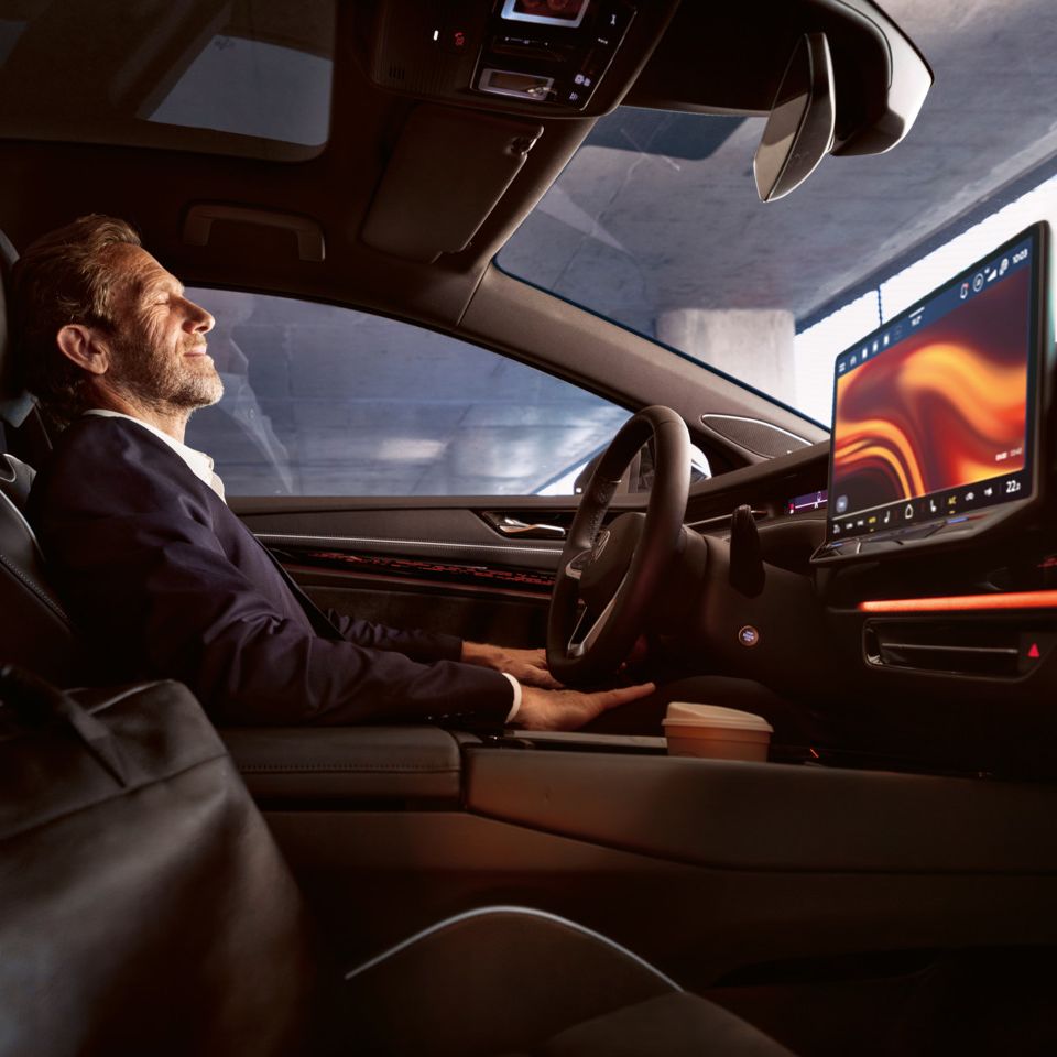 Ein Mann sitzt entspannt im VW ID.7, sichtbar sind Lenkrad und Infotainment-Display.