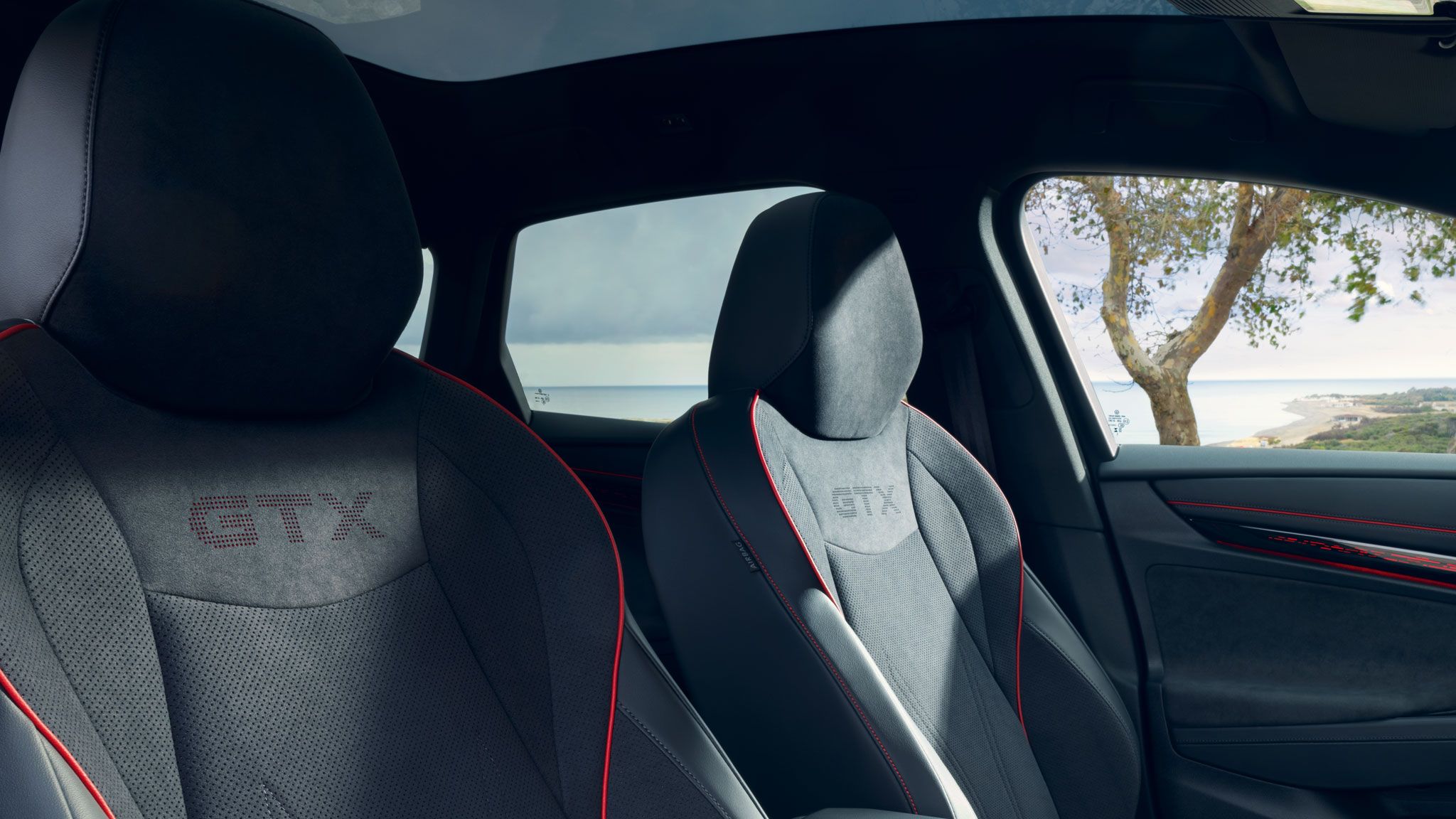 Vordersitze im VW ID.7 GTX mit GTX-Logo und roten Ziernähten.