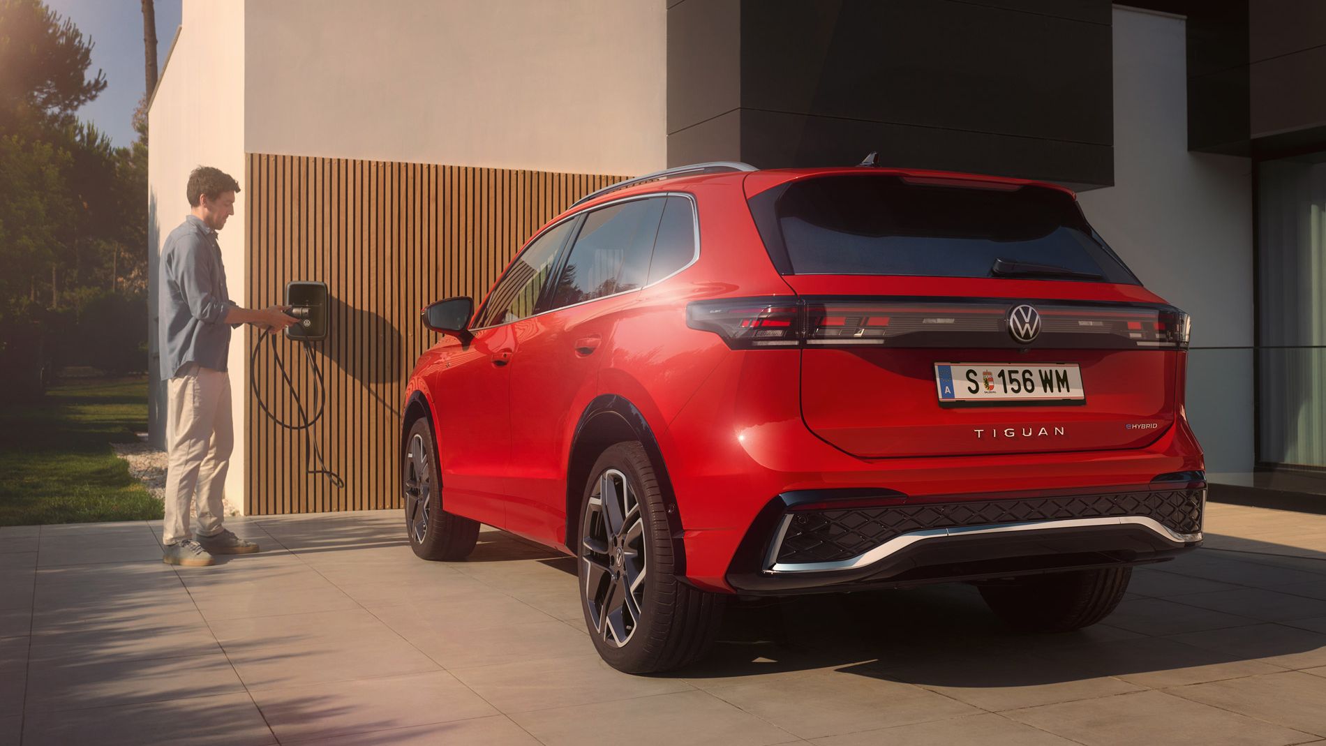 Ein Mann lädt seinen VW Tiguan R-Line eHybrid über seine Wallbox ID. Charger.