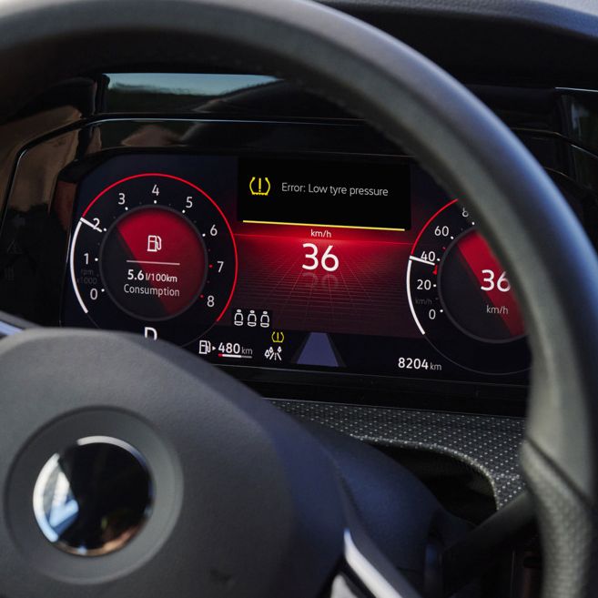 Nahaufnahme des VW-Cockpits mit beleuchtetem Warnlicht